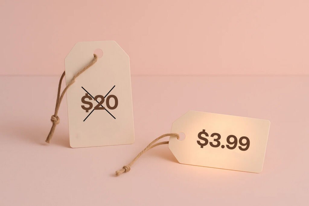 A symbolic image of price tags on a table — one tag with a very high price crossed out, and a smaller tag with a more affordable price highlighted, modern minimalist style, soft pink lighting, 3:2 aspect ratio, no text overlay.